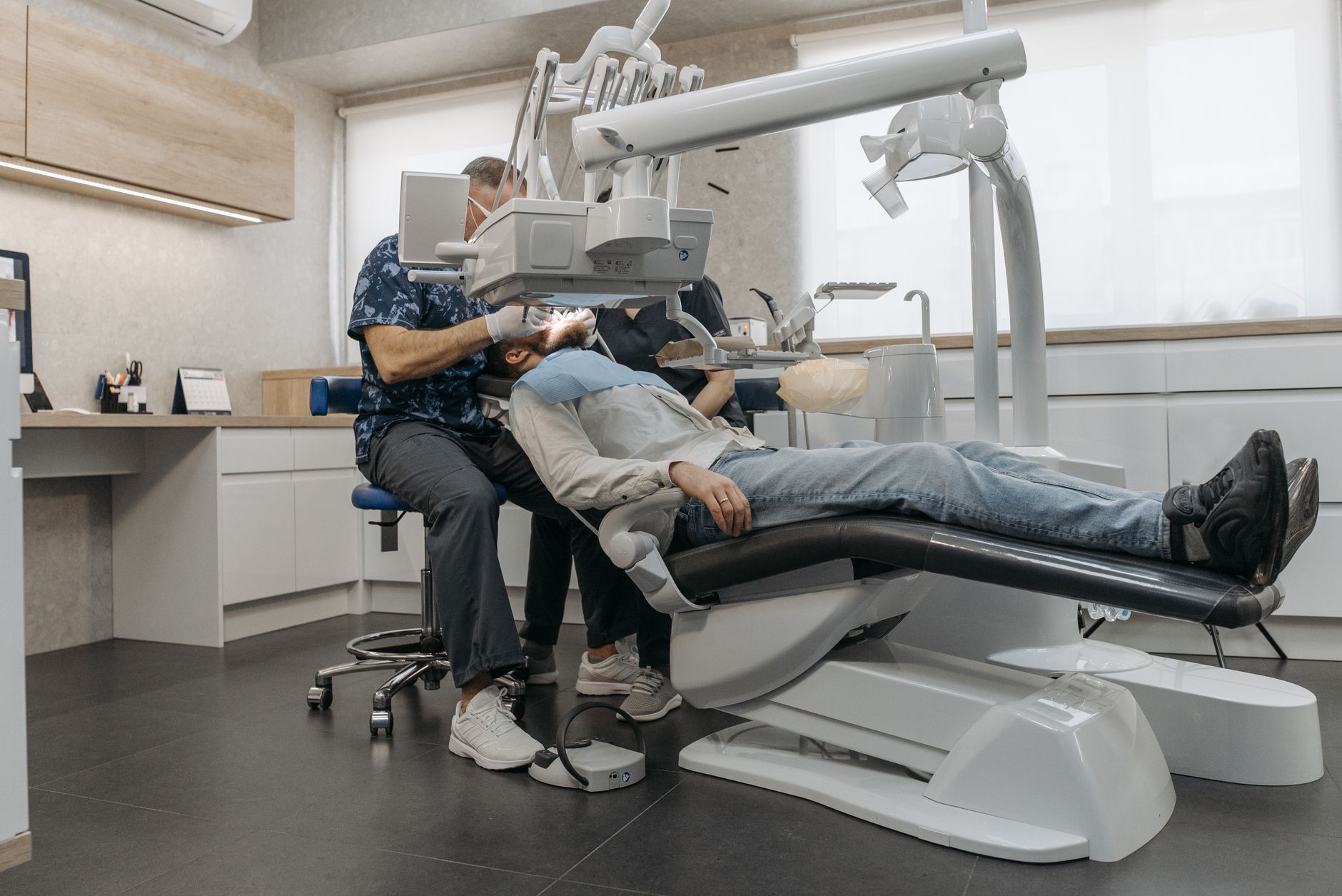 A bright, modern dental treatment chair and equipment in a calm clinic room.