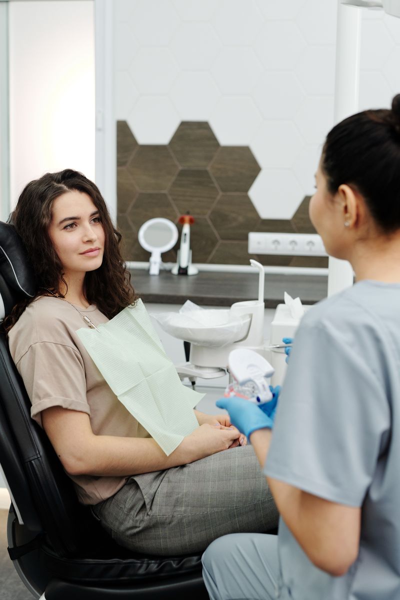 A patient in genuine, relaxed conversation with their dentist during a consultation.